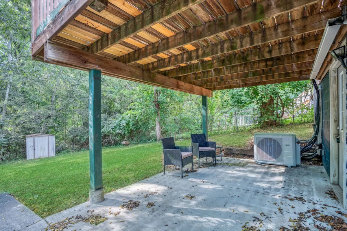 Two outdoor chairs are set on a green lawn near a shed and air conditioning unit. The setup evokes a peaceful moment of enjoying the outdoors, suggesting a leisurely lifestyle where residents can unwind after city adventures.